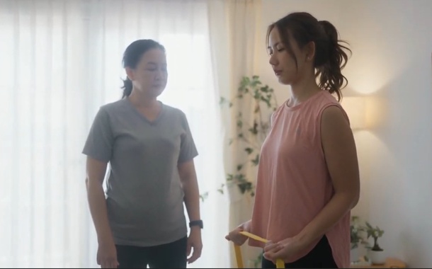Trainer assisting a senior at home
